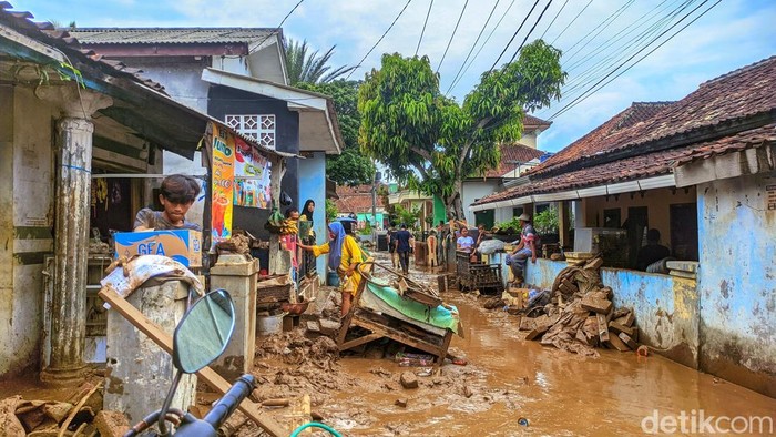 1761651032534-warga-kampung-tugu-saling-membantu-mengevakuasi-motor-dan-perabot-rumah-tangga-yang-rusak-akibat-terendam-lumpur-banyak-warga--1761628876736_169