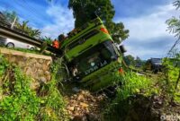 1763357225667-truk-pengangkut-batubara-terjungkir-ke-selokan-di-jalur-cibadak-warungkiara-senin-17112025-warga-membantu-proses-evakuasi-sopi-1763350596388_169