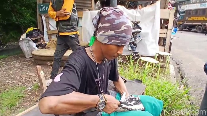 1765818321402-sulaeman-tukang-sol-sepatu-tetap-bekerja-saat-bangunan-di-pinggir-sungai-sukalila-dibongkar-1765785029510_169